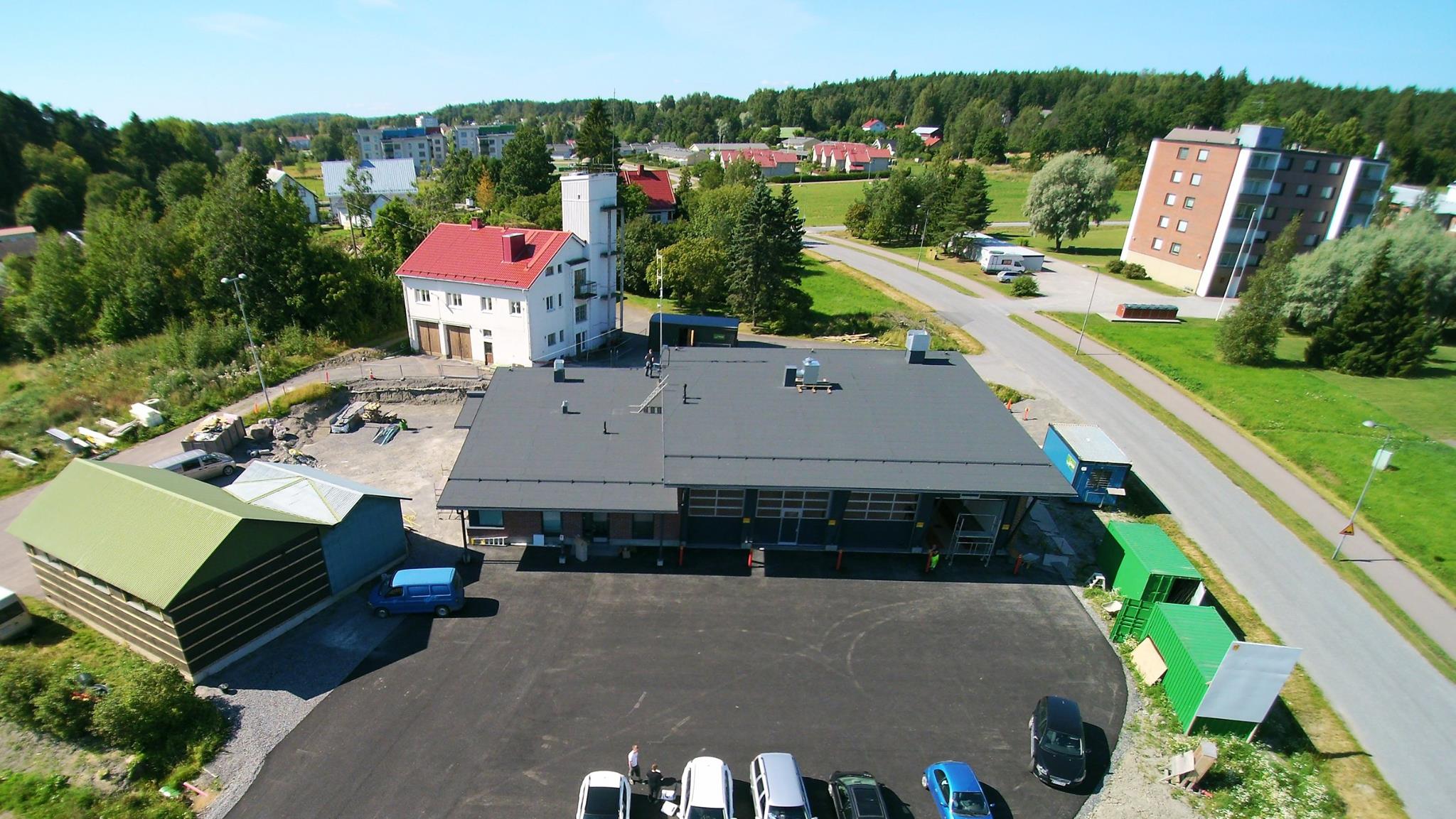 Kuva: Paloasemaa rakennetaan. Taustalla vaalea rakennus on vanha paloasema ja vasemmalla vihreä on kalustohalli sekä harmaa osa "sosiaalitiloja". Kuva: Piikkiön VPK ry.