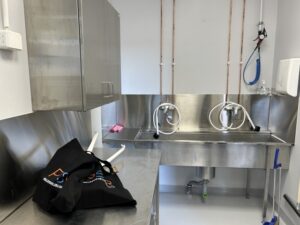 Paloaseman varustehuoltotila, jossa on pesualtaita, kaappeja ja työskentelytaso varusteiden puhdistusta varten.