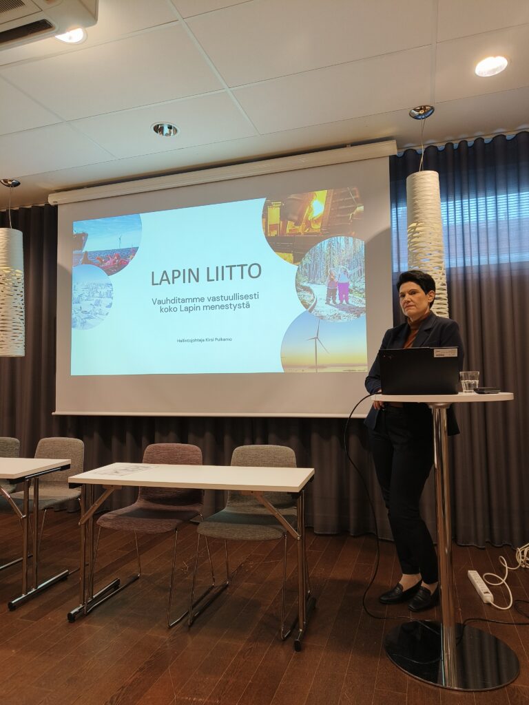 Pulkamo nojaa seisomapöytään samalla kun esitelmöi Lapin alueen asioista.