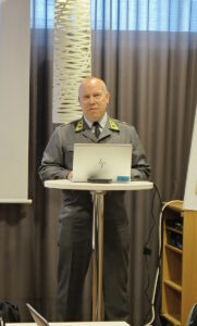 Majuri Arto pitää esitelmää seisomapöydän ääressä tietokoneen takana.