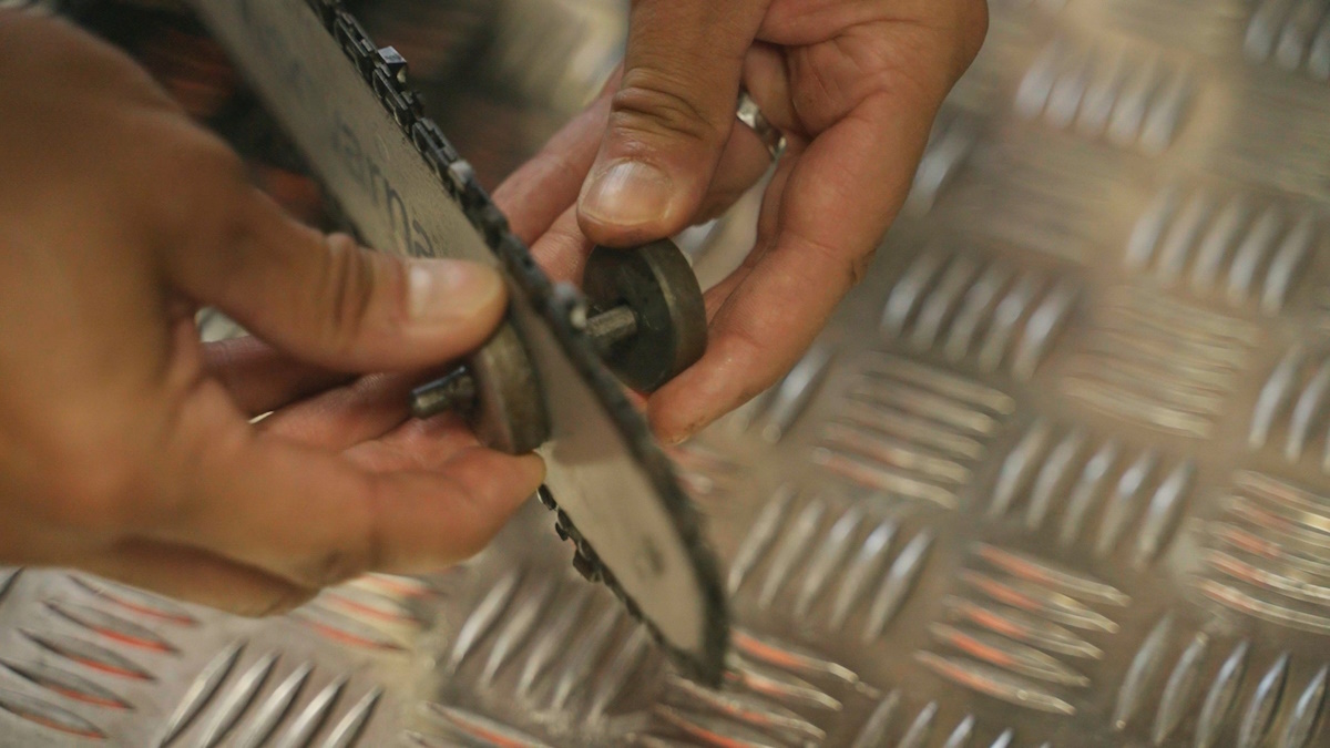 Moottorisahan laippa, jonka läpi menevän metallitangon molemmille puolille asetetaan ympyränmuotoisia magneetteja.